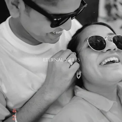 A playful and candid black and white moment. The sunglasses add a cool vibe, but their genuine smiles and laughter are what make this pre-wedding portrait truly special.