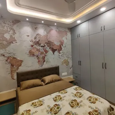 We designed this bedroom as a complete experience, centered around a striking world map statement wall for our travel-loving client. The design integrates floor-to-ceiling matte grey wardrobes for ample storage, a comfortable tufted headboard, and multi-level ceiling cove lighting to create a warm, inviting atmosphere.