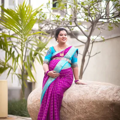 We capture the radiant glow of motherhood during our baby shower photography sessions. This outdoor portrait of an expectant mother in a beautiful saree showcases the joy and anticipation of this special time.