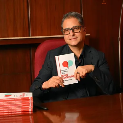 A classic author portrait for Rakesh Kaul, pictured with his book "Winning Markets with Heart Leadership". This shot is perfect for a book launch or press release.
