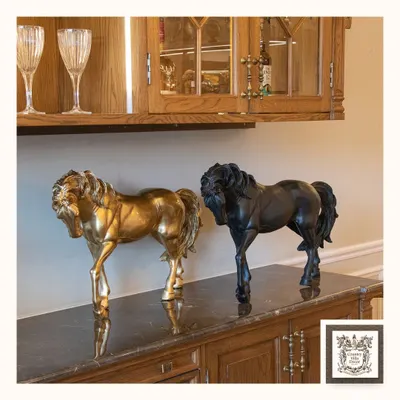 This pair of horse sculptures, one in gold and one in black, exudes power and elegance. Placed on a dark marble-topped sideboard, they create a stunning and luxurious focal point.