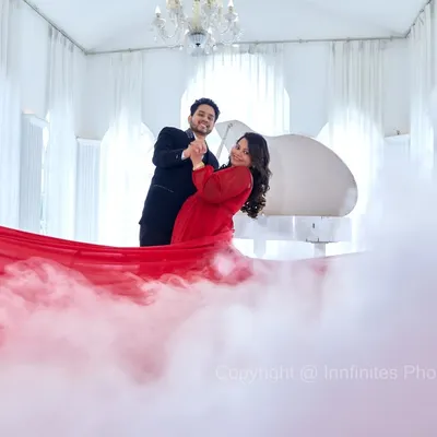 We use props like a flowing red fabric and a smoke machine to create dramatic, high-fashion looks in our elegant white piano studio.