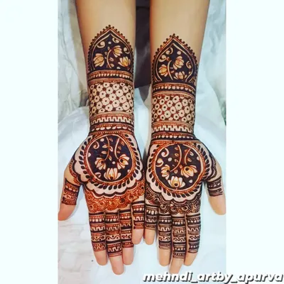 This design features a beautiful reverse-fill technique, where the background is shaded dark to make the lotus and vine patterns on the palm pop. The forearm has a lighter, geometric pattern for contrast.