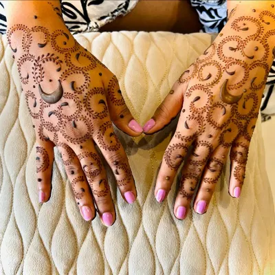 A unique Karwachauth design featuring a repeating crescent moon pattern. The delicate dots and swirls add a modern touch to the traditional festival henna.