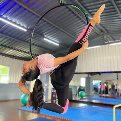 Finding that perfect balance between flexibility and strength. This student is executing a beautiful split variation on the Lyra, a move that requires both open hips and a strong core to hold with such grace.