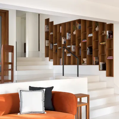 The three levels of this home are connected by a custom, climbing bookcase that serves as the focal point. The wide steps double as informal seating, making the entire transitional space functional and inviting.