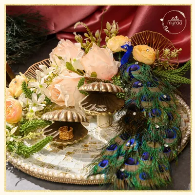 For engagements, I design platters that are as memorable as the moment itself. This piece, from my Ibtidaa collection, features a majestic peacock motif, delicate florals, and shell-shaped ring holders on a mosaic tray, creating a truly regal start to a new journey.