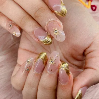 This look is all about luxury. We used a soft, translucent base to create a canvas for these stunning 3D gold swirls and celestial starbursts, each accented with tiny rhinestones. It’s a high-fashion, glamorous set perfect for making a statement.