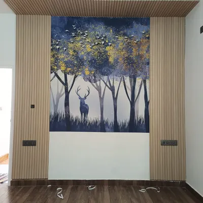 This accent wall is a great example of mixing materials. The serene forest and deer mural is flanked by light wood fluted panels, creating a modern yet natural focal point.