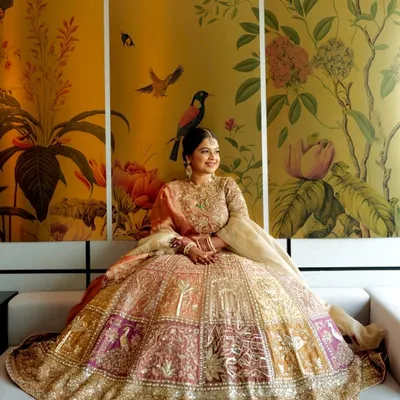 This is a look I created for my best friend, and it was pure magic. The pastel and gold lehenga paired with a soft, glowing makeup look against this stunning floral backdrop is what bridal dreams are made of.