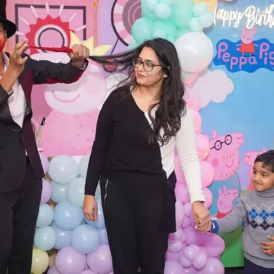 A magician captivates the audience with an interactive trick during a birthday party, creating a moment of wonder for both kids and parents.