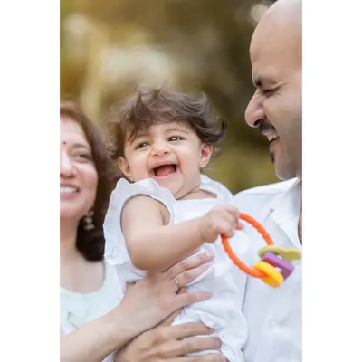 A perfect family portrait filled with laughter. Baby Anwita shares a joyful moment with her parents during her first birthday shoot. Including family in the photos creates memories for everyone.