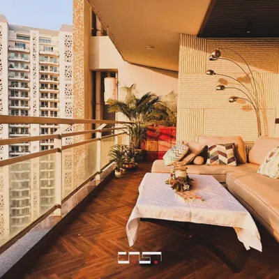 This spacious balcony is designed as a luxurious outdoor lounge, with a large L-shaped sofa, herringbone wood flooring, and a modern floor lamp, perfect for enjoying the sunset.