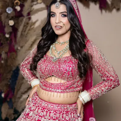 A vibrant pink lehenga paired with a dramatic smokey eye. This is a student's work from our portfolio day, showing their skill in creating bold, contemporary bridal looks.