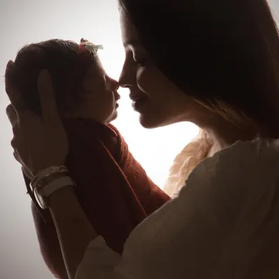 A signature silhouette portrait of a mother and her newborn baby. This artistic style strips away distractions, leaving only the pure emotion and outline of their connection.