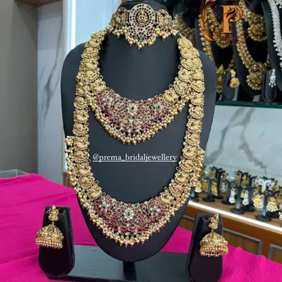 A stunning antique-finish peacock design choker and haram set. This is a very popular choice for Muhurtham ceremonies, featuring intricate work with kemp stones.