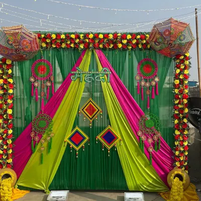 A vibrant outdoor Mehendi backdrop. I used a combination of green, yellow, and pink drapes, Rajasthani umbrellas, dreamcatchers, and marigold floral arrangements for a festive and colorful look.