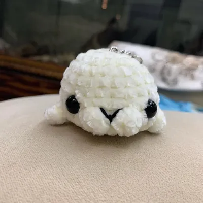 This is the finished no-sew seal, made with a chunky white yarn to look like a baby harp seal. The pattern includes instructions for the bobble stitches that form its cute little fins.