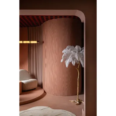 This detail shot from one of our award-winning projects shows our love for sculptural forms. The curved wall, finished in warm wood, creates a soft, enclosing feeling, complemented by an artistic floor lamp.