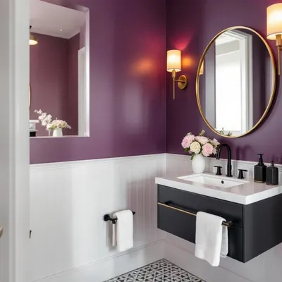 This powder room makes a bold statement with its rich purple walls and white wainscoting. The floating vanity, gold accents, and patterned floor tiles create a look of modern elegance.