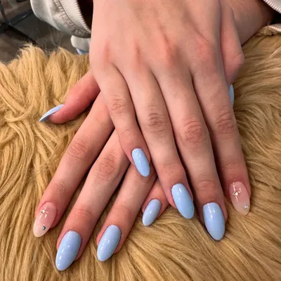 A beautiful example of simple elegance. This manicure features a solid, glossy baby blue polish on perfectly shaped oval nails, with a subtle glitter accent nail for a touch of sparkle.