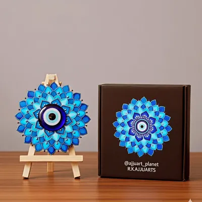 A classic evil eye mandala, hand-painted with shades of blue to promote calm and protection. This piece is shown on a mini easel, making it a perfect decorative accent for a tabletop or office desk.