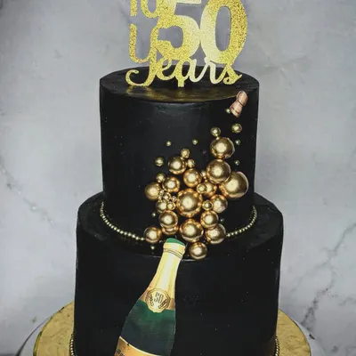 Turning half a century old is a big deal, and it calls for a showstopper cake. This two-tiered black and gold cake with a champagne bottle theme is the definition of a celebration centerpiece.