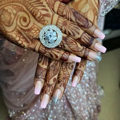 This stunning silver-finish floral cocktail ring is one of our favorite statement pieces. It adds the perfect touch of sparkle for an engagement, reception, or festive party. We love how it complements the detailed mehndi and elegant nails, creating a complete, polished look for your special day.