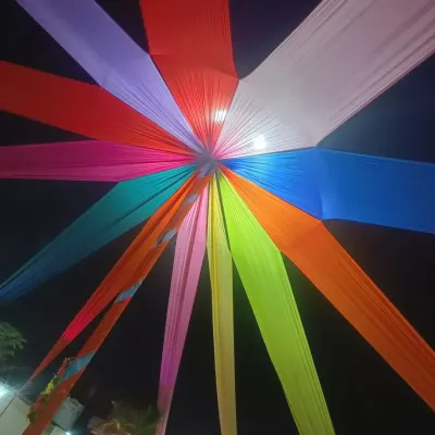 A colorful fabric canopy is a great way to add life to an outdoor or tented event. Here, I arranged multiple bright fabrics in a starburst pattern to create a vibrant ceiling that looks amazing day or night.