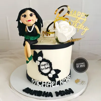 A chic and elegant cake for a fashion lover, featuring a handmade fondant figure, a Michael Kors logo, and classic black and white details.