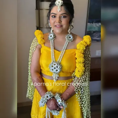 For this bride's Haldi ceremony, I created a full set of fresh flower jewellery and a matching floral dupatta, also known as a 'shela'. The bright yellow marigolds and contrasting white flowers create a look that is both traditional and vibrant.