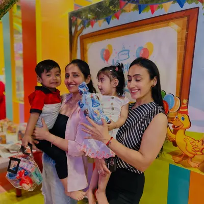 Mothers and toddlers pose together during a birthday celebration, capturing the happy, communal spirit of our club.