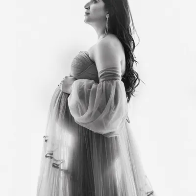 A black and white version of a classic maternity pose. Removing the colour emphasizes the beautiful light, the texture of the gown, and the serene expression of the mother-to-be.