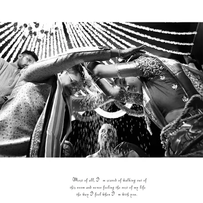 The iconic Talambralu ritual of a Telugu wedding, captured in a dramatic black and white low-angle shot that emphasizes the joy and energy of the moment.