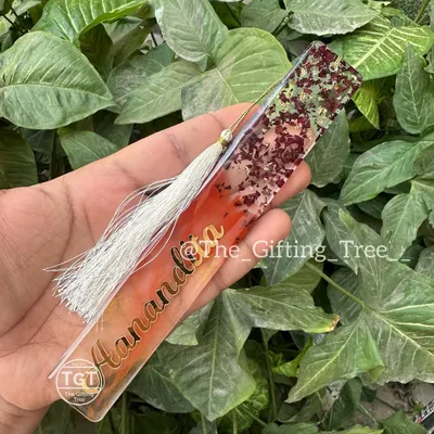 This is a personalized resin bookmark I created, featuring the name "Aanandita" in gold. The design includes a mix of colors and glitter, with a tassel to finish it off.