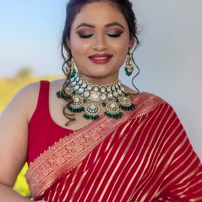 Understated glam for a special role. This soft glam look was created for a wedding guest, featuring a warm smokey eye and a classic red lip to complement her beautiful red saree.