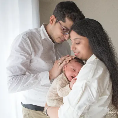 A beautiful, light-filled portrait of new parents adoring their sleeping baby. These are the quiet, intimate moments that truly define the newborn experience. I aim to capture the overwhelming love and wonder of this special time.