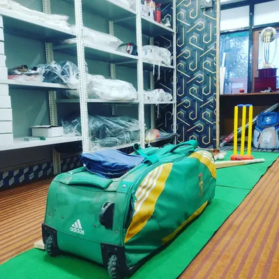 Our store stocks a variety of gear, including this Adidas wheelie kit bag. You can also see our wickets and other equipment ready for players.