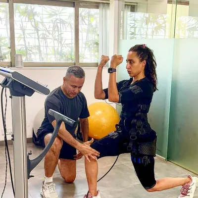 Here I am guiding my daughter, Namrata, through a balance and strength exercise. This shows how we combine different fitness principles with EMS.