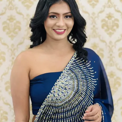 A touch of glam for a special evening out. This look features defined eyes with winged liner, softly contoured cheeks, and a beautiful berry lip color that complements her royal blue saree.