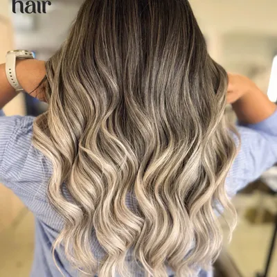 Sipping bubbly, feeling lovely, living lovely. This stunning champagne blonde balayage is the epitome of glamour, with a seamless melt from dark roots to platinum ends.