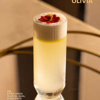 Meet Olivia. A subtle and unforgettable cocktail crafted with gin, extra virgin olive oil, fresh basil, and egg white for a silken texture. It is balance in a glass.