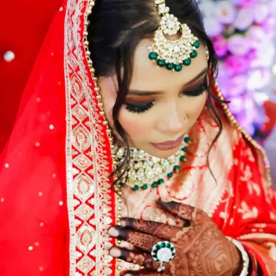 A complete view of a traditional bridal look I created. The rich red dupatta frames her face beautifully, highlighting the bold eye makeup and the intricate kundan and emerald jewelry. My goal is to ensure your makeup works in harmony with your entire bridal ensemble.
