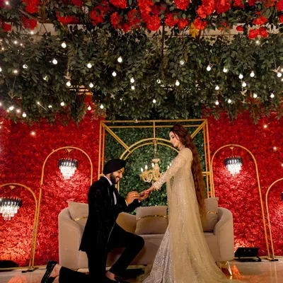 The moment it becomes official. I love capturing the proposal during a ring ceremony, set against a stunning backdrop of red roses and elegant decor.