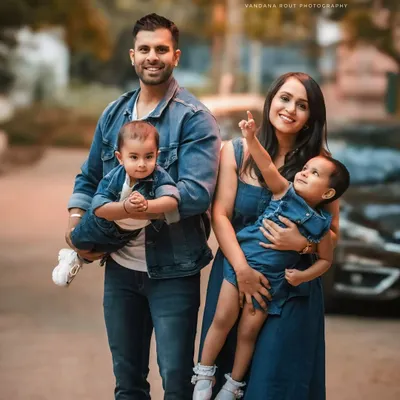 A perfect family portrait, with everyone dressed in matching denim. This outdoor shot captures a candid moment of joy and togetherness, showing the fun and love this family shares.