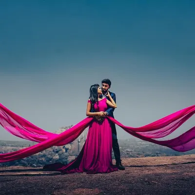 This stunning magenta trail gown is a favorite for pre-wedding photoshoots. The flowing fabric creates incredible, dramatic shots against any backdrop, ensuring your photos are unforgettable.