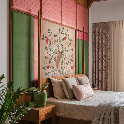 This bedroom, from "The Varnam Edit," features a queen-sized bed with a custom headboard made of silk, brocade, and a hand-painted central panel. The design brings heritage and quiet power into the room.