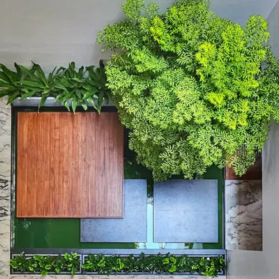 An overhead view of a courtyard design, where a koi pond, wood deck, and lush greenery come together under a skylight.
