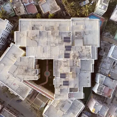 An aerial top-down view of a large apartment complex on Bannerghatta Road, showing the potential for clean energy generation across multiple rooftops. We design systems that maximize the available space for collective benefit.