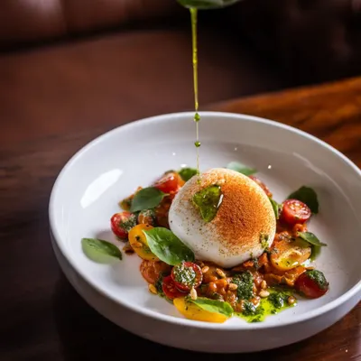 A perfect meal can start with something fresh and vibrant. My Burrata salad features a creamy center that spills onto a bed of sweet cherry tomatoes and basil pesto. A final drizzle of extra virgin olive oil makes it simple, elegant, and incredibly delicious.